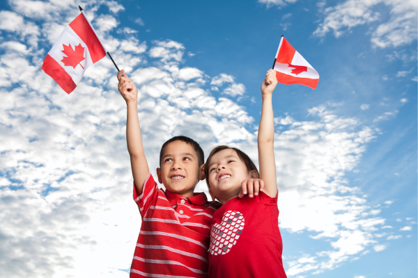 Two young children celebrate Canada Day by dressing in red and white.
