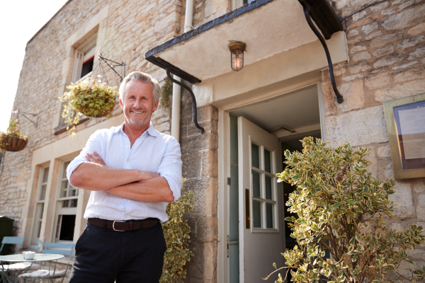 A man is standing at the open door entry of a nice rental apartment.