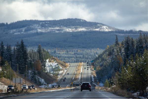 Cars travelling along a highway in British Columbia with mountains in the background. 