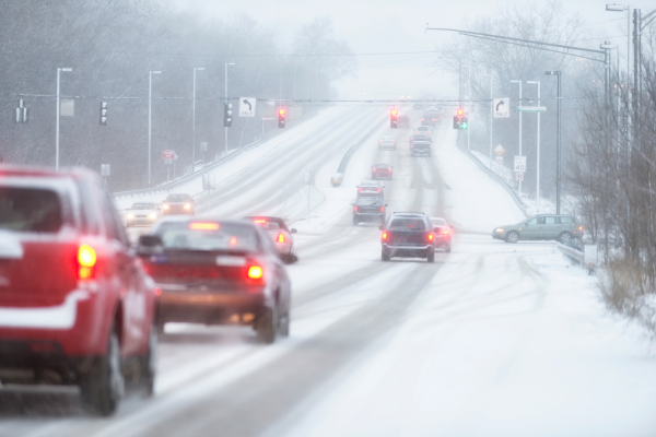 Cars driving in Canada on a slippery snow covered road.