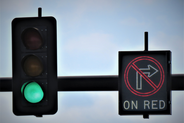 Traffic lights with a green light and one sign that shows no right turn on a red light. 