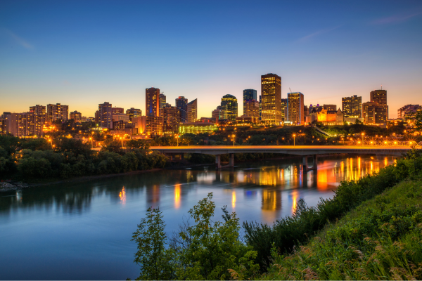 Edmonton's illuminated skyline reflects off the water. The most recent housing market report shows home prices in Edmonton remain a bargain