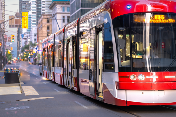 A Toronto streetcar is travelling along King Street. Living close to work will help you avoid a lengthy commute to work. 