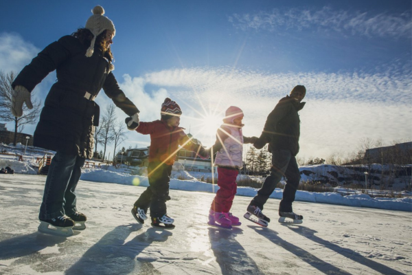 A family is skating an outdoor rink in Sudbury, Ontario on the Family Day long weekend. 