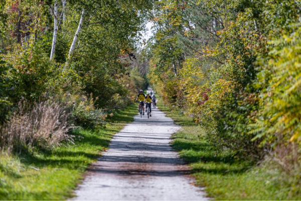 People are cycling on a nature trail on a long weekend in Ontario.  