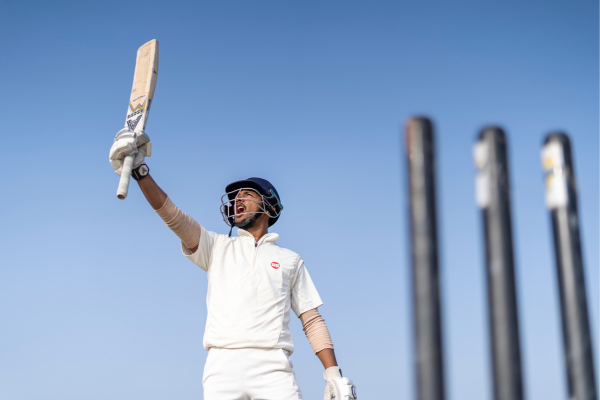 A male player is holding his bat in cricket world cup victory. 