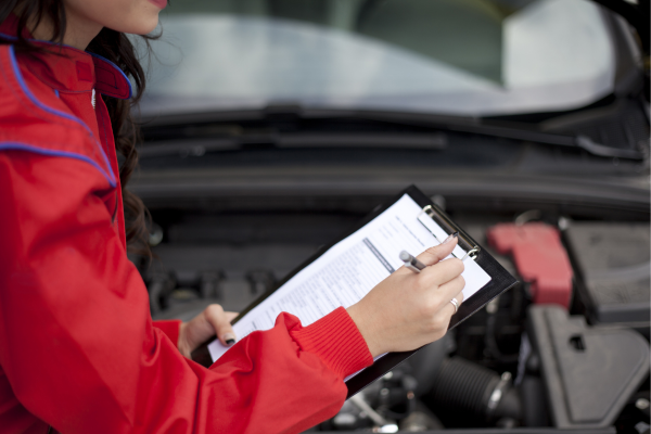 A woman is doing a safety check of her car to ensure it is winter-ready.